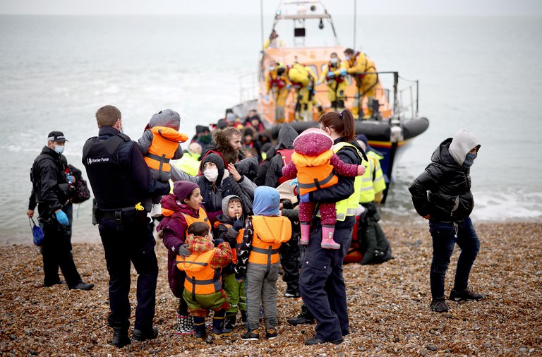 Migrants are brought ashore by RNLI Lifeboat staff, police officers and Border Force staff, after having crossed the channel, in Dungeness, Britain, Nov. 24, 2021. Credit: Reuters