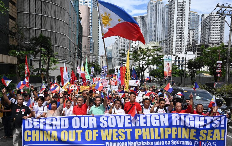 Protesters opposed to China's encroachment in Philippines waters carrying national flags and placards march towards the Chinese consulate in Manila on April 9, 2019.  Credit: AFP